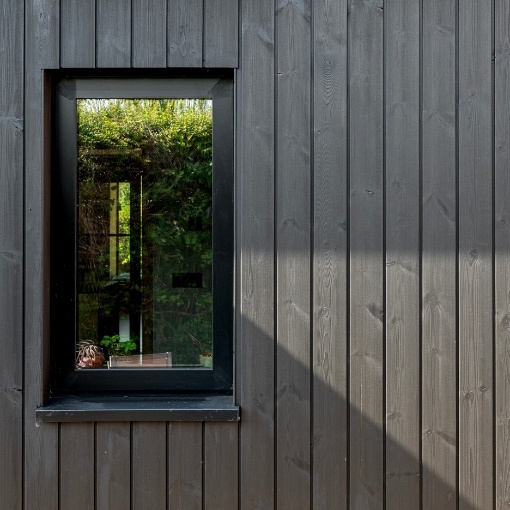 MillCoat Charcoal Black ThermoWood Pine timber cladding around window.
