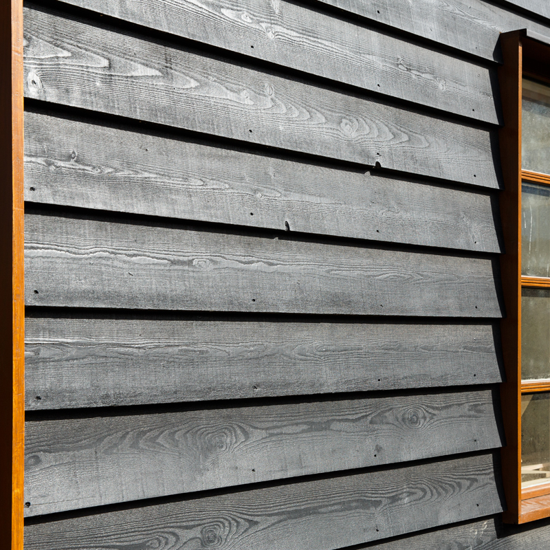 Section of barn wall finished in black coated larch