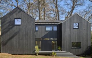 Black timber clad property with two pitched sections.