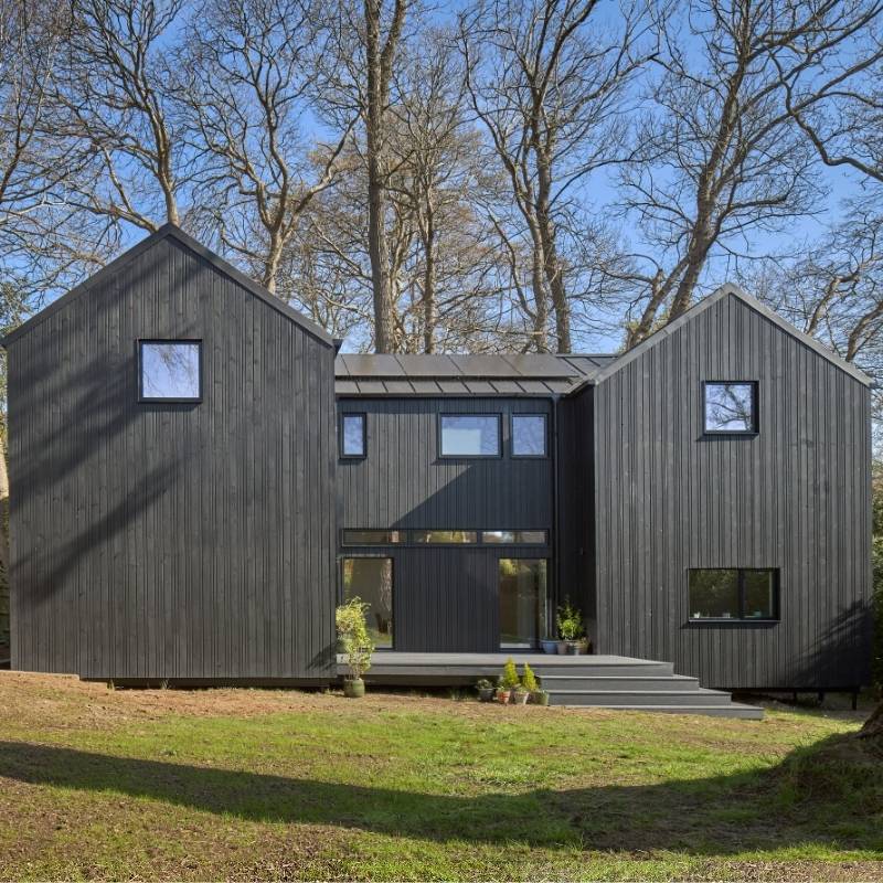 Black timber clad property with two pitched sections.