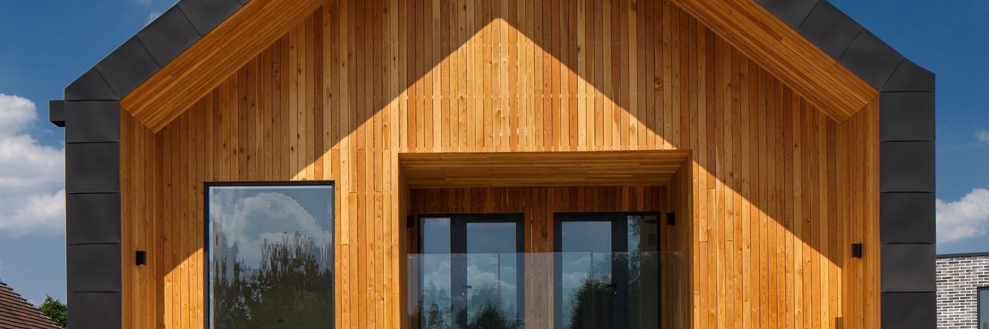 MillworksLtd_TimberTattle_DurableTImberCladding Larch timber cladding shown on a balcony pitched roof.