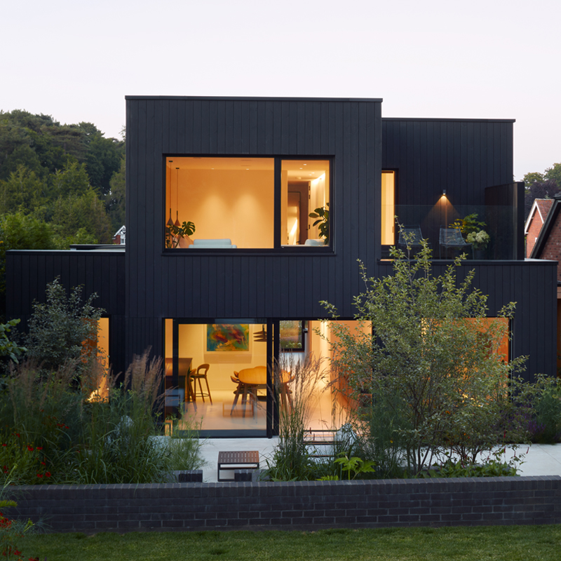 Blackwood house exterior in Black ThermoWood® Pine cladding, photographed at dusk.