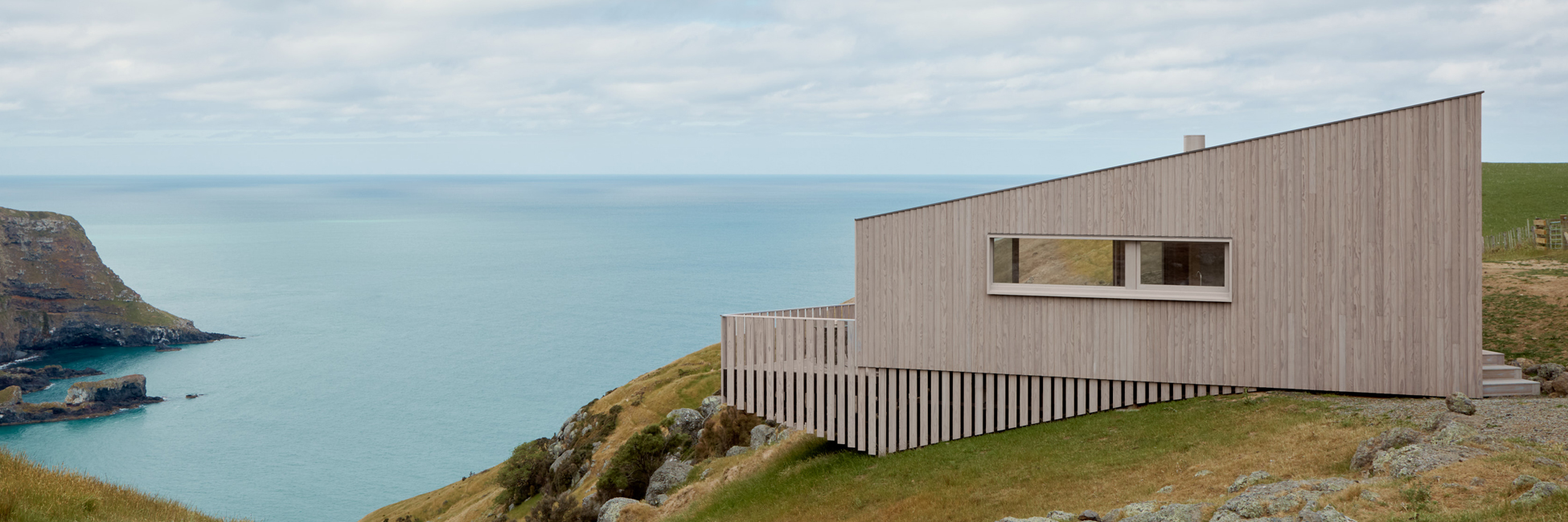 MillworksLtd-Imbue-cladding-MillProtect-WhiteGrey-hero Cabin overlooking sea built with Imbue timber cladding finished in MillProtect White Grey coating