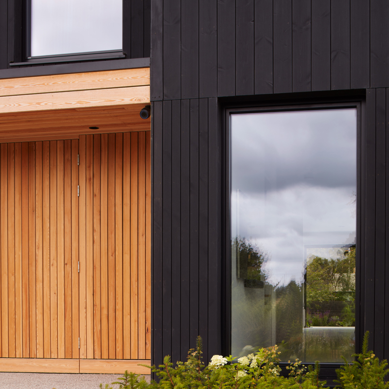 Closeup photograph of Black ThermoWood® Pine and Organowood treated Larch cladding.