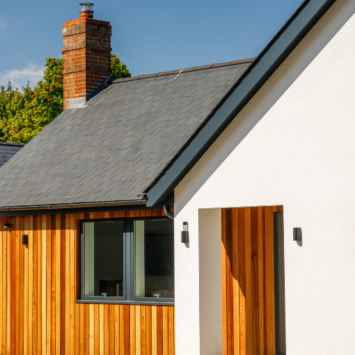 Millworks Western Red Cedar extension contrasting with original white render bungalow.